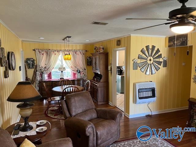 interior space featuring ceiling fan, dark hardwood / wood-style flooring, a textured ceiling, and heating unit