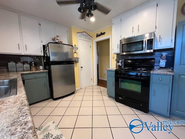 kitchen with white cabinets, appliances with stainless steel finishes, ceiling fan, and light tile patterned flooring