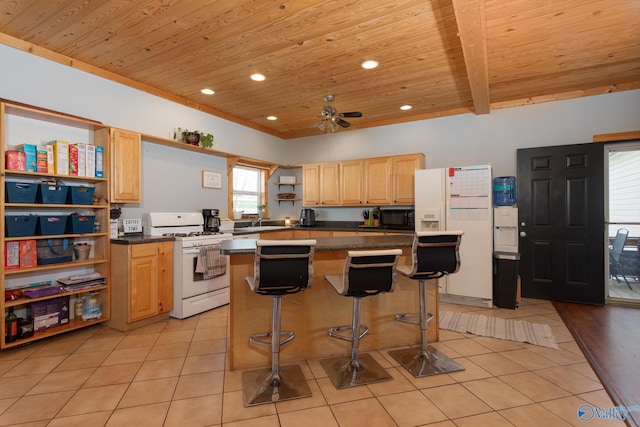 kitchen featuring light tile patterned flooring, ceiling fan, white appliances, a center island, and a breakfast bar