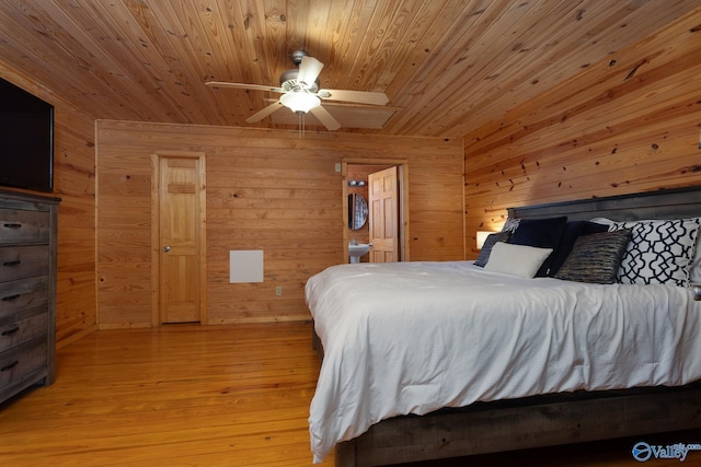 bedroom with light hardwood / wood-style floors, wood walls, and wooden ceiling