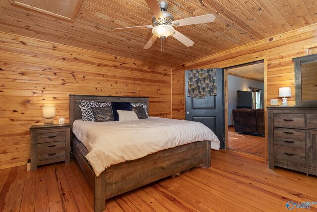 bedroom with wooden walls, hardwood / wood-style flooring, wood ceiling, and ceiling fan