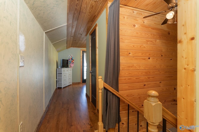 hall with dark wood-type flooring, wooden ceiling, wooden walls, and lofted ceiling