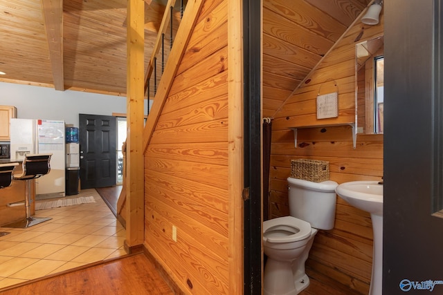 bathroom featuring wooden walls, wood ceiling, toilet, hardwood / wood-style flooring, and vaulted ceiling