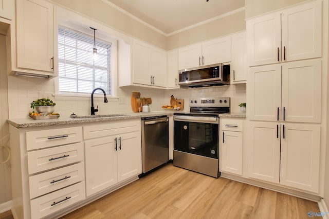 kitchen with white cabinets, appliances with stainless steel finishes, sink, and light hardwood / wood-style flooring