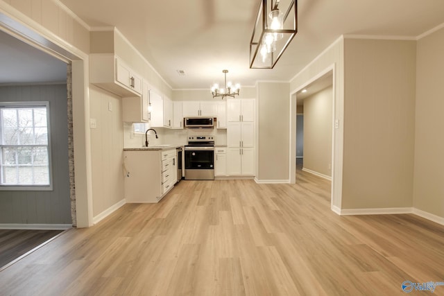 kitchen with sink, white cabinetry, ornamental molding, and stainless steel appliances