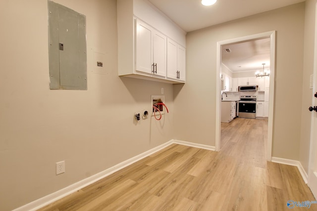 laundry room featuring light hardwood / wood-style floors, a notable chandelier, washer hookup, electric panel, and sink