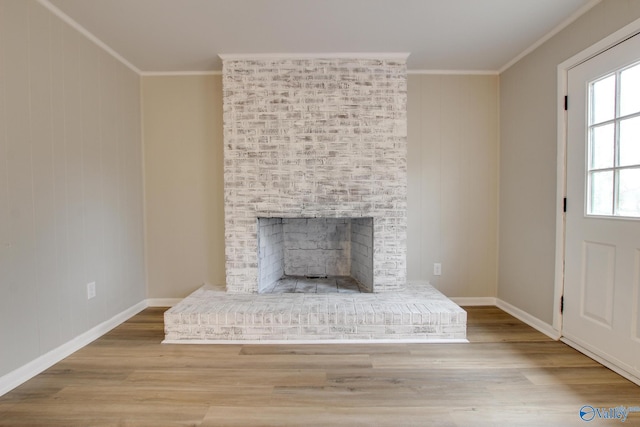 interior details with a brick fireplace, ornamental molding, and wood-type flooring