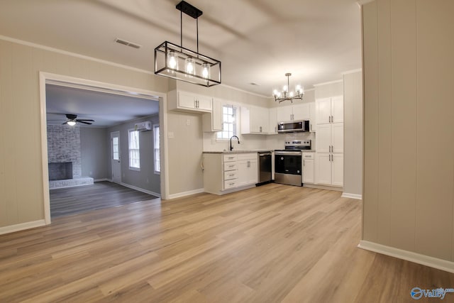 kitchen featuring appliances with stainless steel finishes, ceiling fan with notable chandelier, and white cabinetry