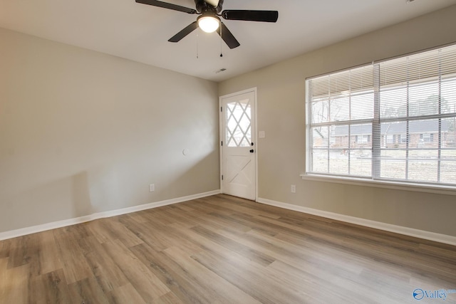 foyer entrance featuring light wood-type flooring, ceiling fan, and a wealth of natural light