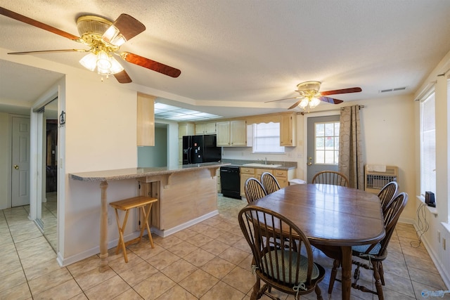 tiled dining area with a wall mounted air conditioner, sink, a textured ceiling, and ceiling fan