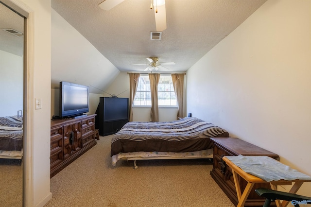 bedroom with vaulted ceiling, a textured ceiling, ceiling fan, and carpet flooring