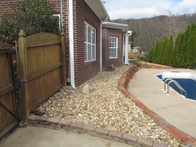 view of property exterior featuring a patio area and an empty pool