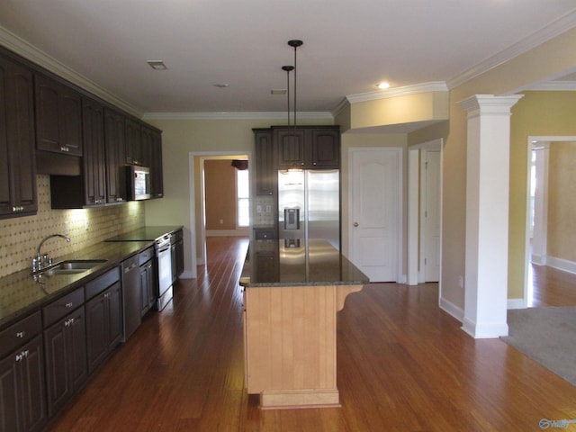 kitchen featuring ornate columns, appliances with stainless steel finishes, sink, dark brown cabinets, and ornamental molding