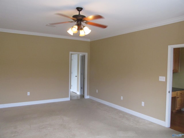 carpeted empty room featuring ceiling fan and ornamental molding