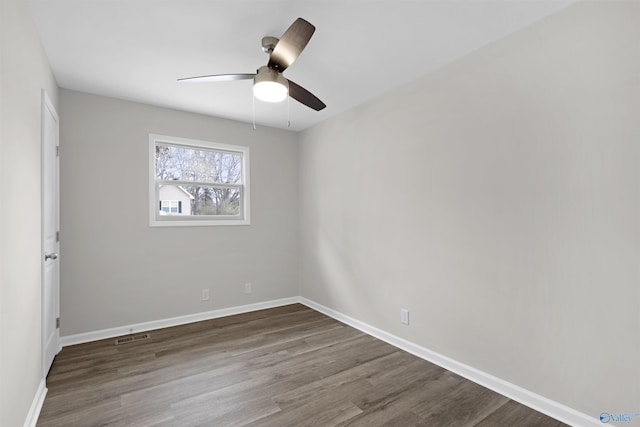 spare room with ceiling fan and dark hardwood / wood-style flooring