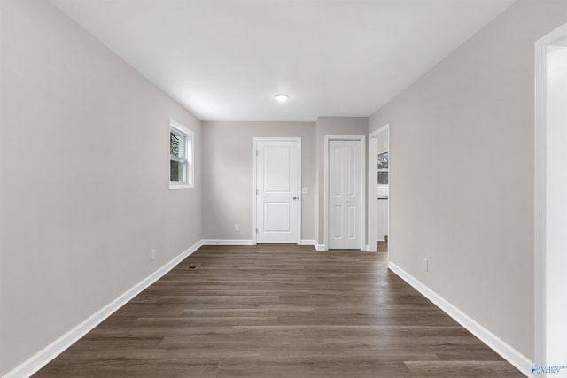 empty room with dark hardwood / wood-style flooring