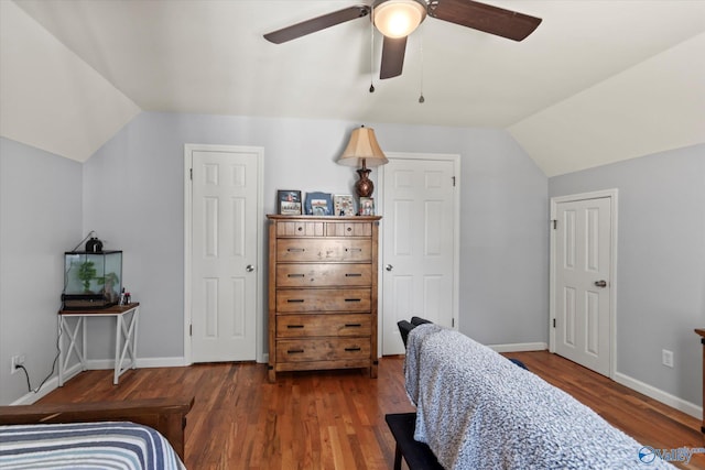 bedroom featuring baseboards, lofted ceiling, and wood finished floors