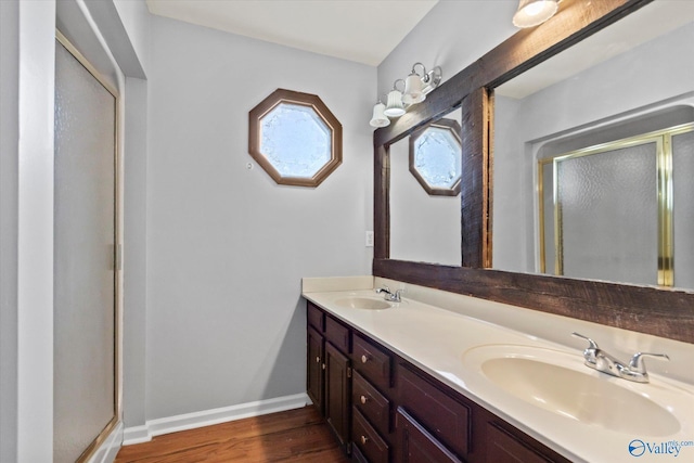 full bath featuring a sink, baseboards, and a shower stall