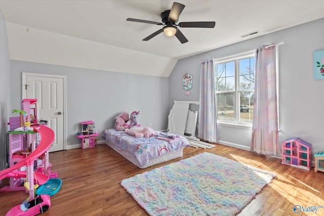 bedroom featuring visible vents, ceiling fan, baseboards, lofted ceiling, and wood finished floors