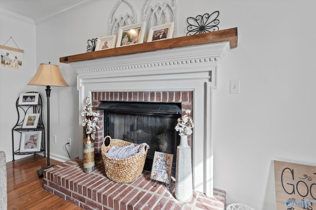 interior details with wood finished floors, a fireplace, and ornamental molding