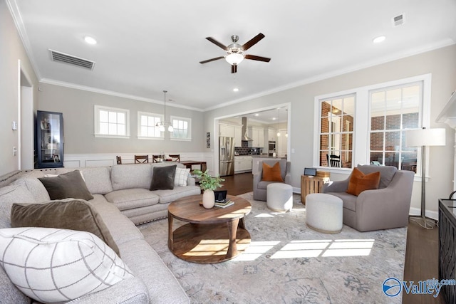 living area featuring visible vents, crown molding, and wood finished floors