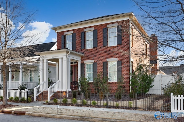 view of front facade with brick siding and a fenced front yard