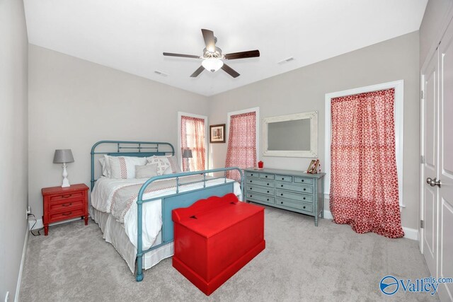 bedroom with a ceiling fan, light colored carpet, visible vents, and baseboards