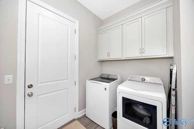 washroom featuring independent washer and dryer, wood finished floors, cabinet space, and baseboards