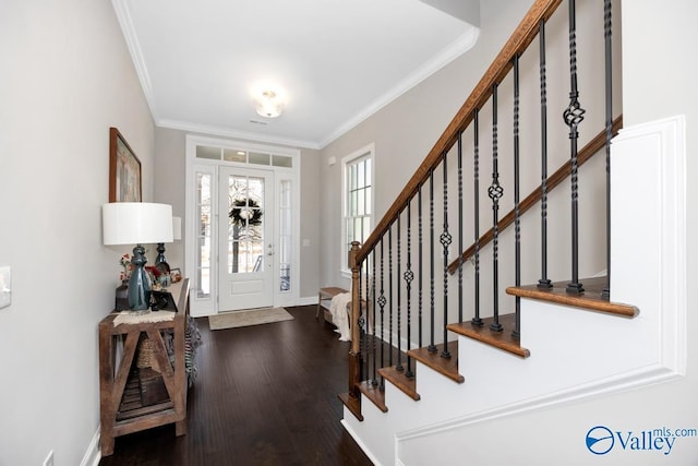 foyer entrance featuring stairway, crown molding, baseboards, and wood finished floors