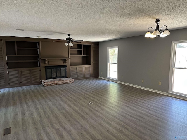 unfurnished living room with wood finished floors, a fireplace, baseboards, visible vents, and a textured ceiling