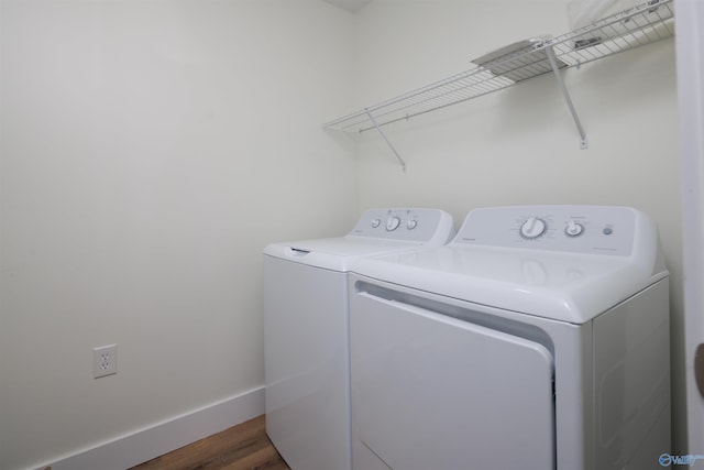 clothes washing area with dark wood-type flooring and washer and clothes dryer