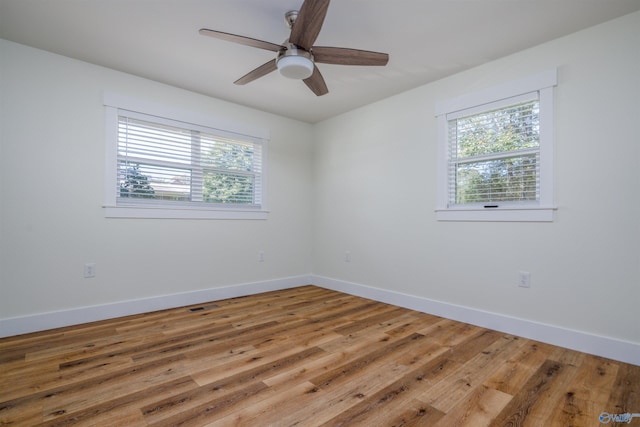 spare room with ceiling fan, plenty of natural light, and hardwood / wood-style floors