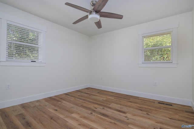 unfurnished room with ceiling fan, a wealth of natural light, and hardwood / wood-style floors