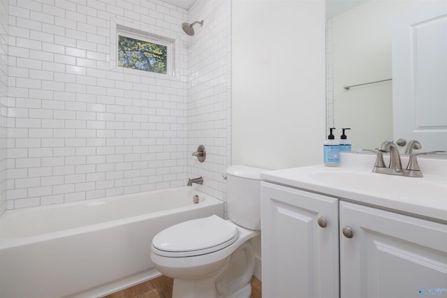 full bathroom featuring vanity, tiled shower / bath combo, hardwood / wood-style flooring, and toilet