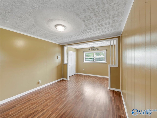 201 10th Ave NW, Decatur, AL 35601 - spare room featuring wood finished floors, a textured ceiling, baseboards, and wood walls