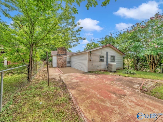201 10th Ave NW, Decatur, AL 35601 - rear view of house featuring central AC unit, driveway, and a chimney