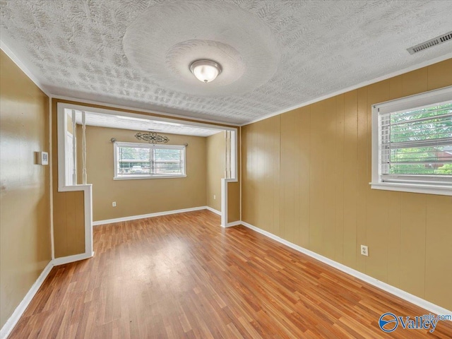 201 10th Ave NW, Decatur, AL 35601 - unfurnished room featuring wood finished floors, plenty of natural light, baseboards, and a textured ceiling