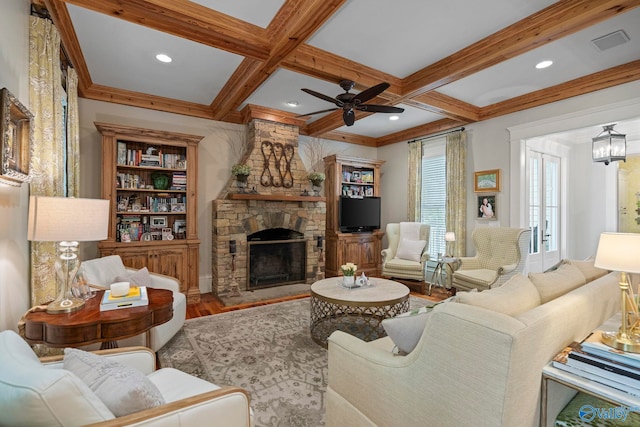 19 Ledges Main SE, Huntsville, AL 35802 - living room featuring wood finished floors, a ceiling fan, beamed ceiling, a stone fireplace, and coffered ceiling