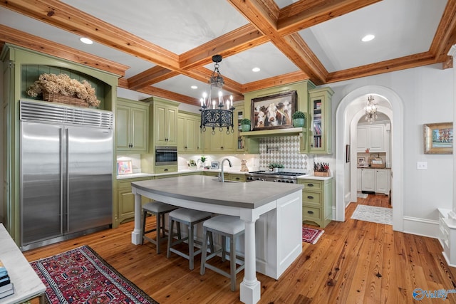19 Ledges Main SE, Huntsville, AL 35802 - kitchen featuring appliances with stainless steel finishes, green cabinets, a chandelier, tasteful backsplash, and beamed ceiling