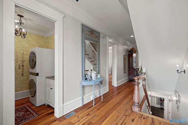 19 Ledges Main SE, Huntsville, AL 35802 - hallway featuring stacked washer and clothes dryer, a chandelier, crown molding, light wood-type flooring, and wallpapered walls