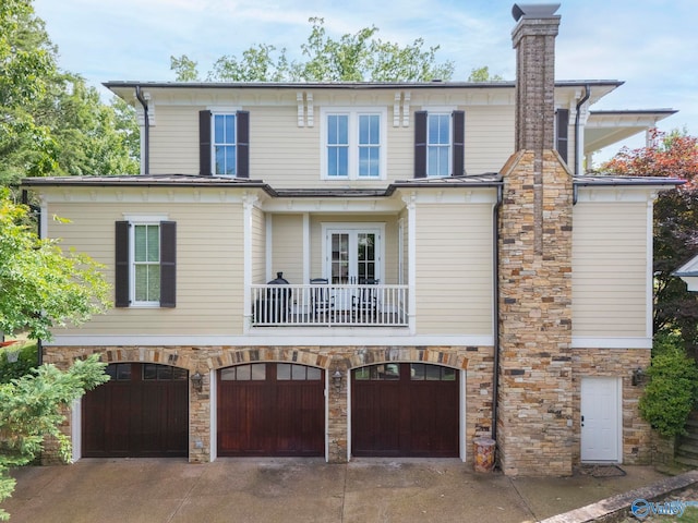 19 Ledges Main SE, Huntsville, AL 35802 - view of front of property featuring a balcony, concrete driveway, an attached garage, stone siding, and a chimney