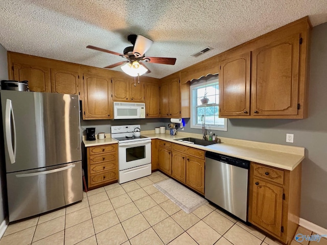 28035 Holland Gin Rd, Elkmont, AL 35620 - kitchen featuring appliances with stainless steel finishes, brown cabinetry, light countertops, ceiling fan, and a textured ceiling