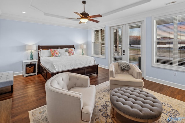 bedroom with ornamental molding, dark hardwood / wood-style floors, access to outside, and a tray ceiling