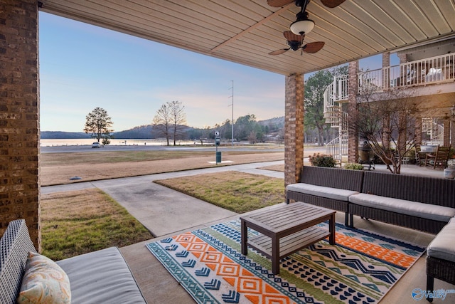 view of patio / terrace featuring an outdoor living space, a water view, and ceiling fan