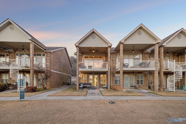 view of front of house featuring a balcony and ceiling fan