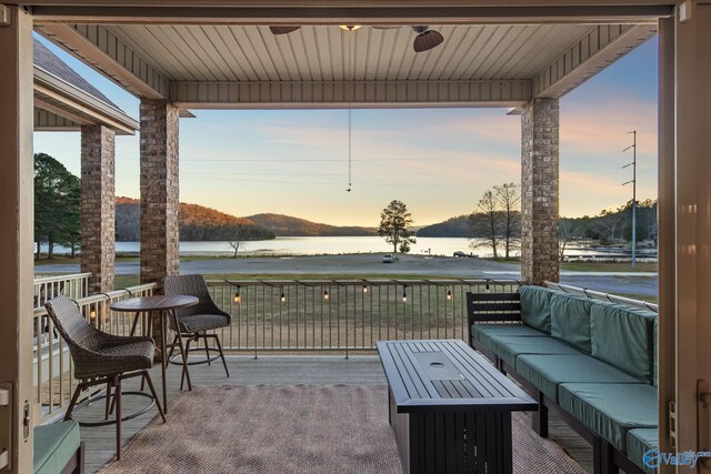 patio terrace at dusk with a water view and an outdoor living space