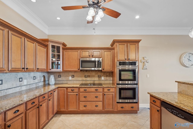 kitchen with crown molding, appliances with stainless steel finishes, backsplash, light stone countertops, and light tile patterned flooring