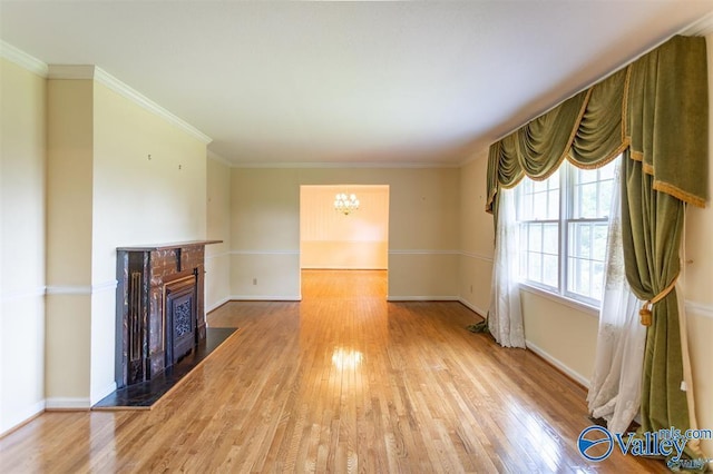 unfurnished living room with light hardwood / wood-style flooring, a notable chandelier, and ornamental molding