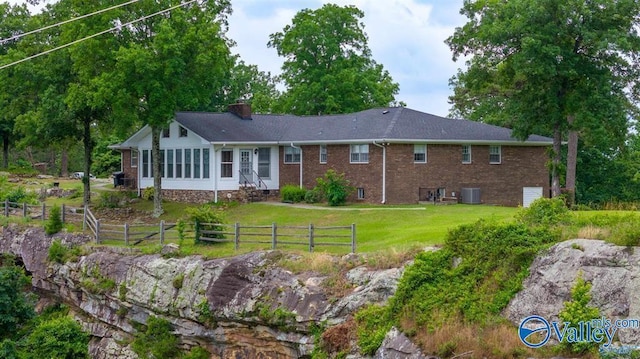 back of house featuring central AC unit and a yard