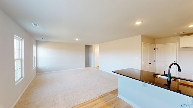 kitchen featuring white cabinetry, sink, and light wood-type flooring